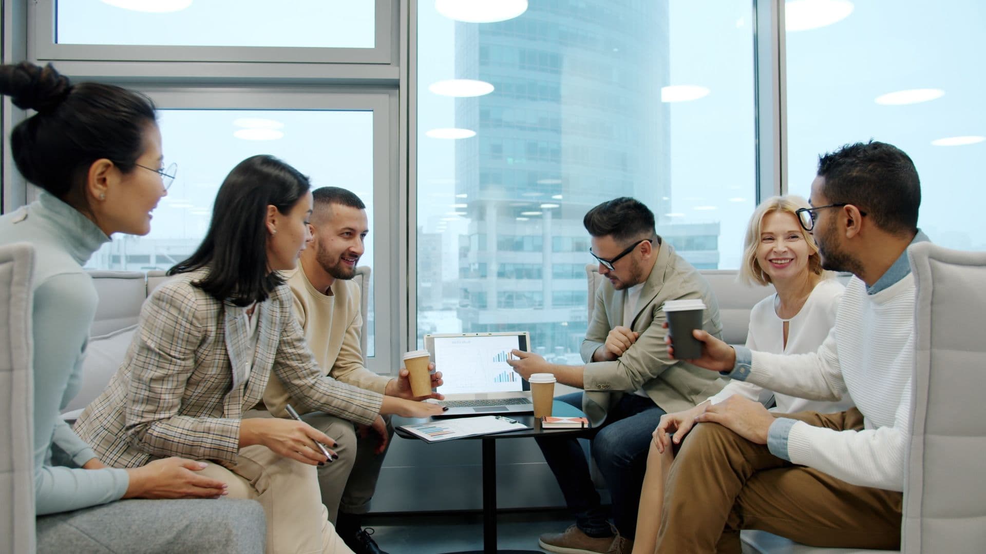 Xquantum team collaborating around a laptop in a modern office